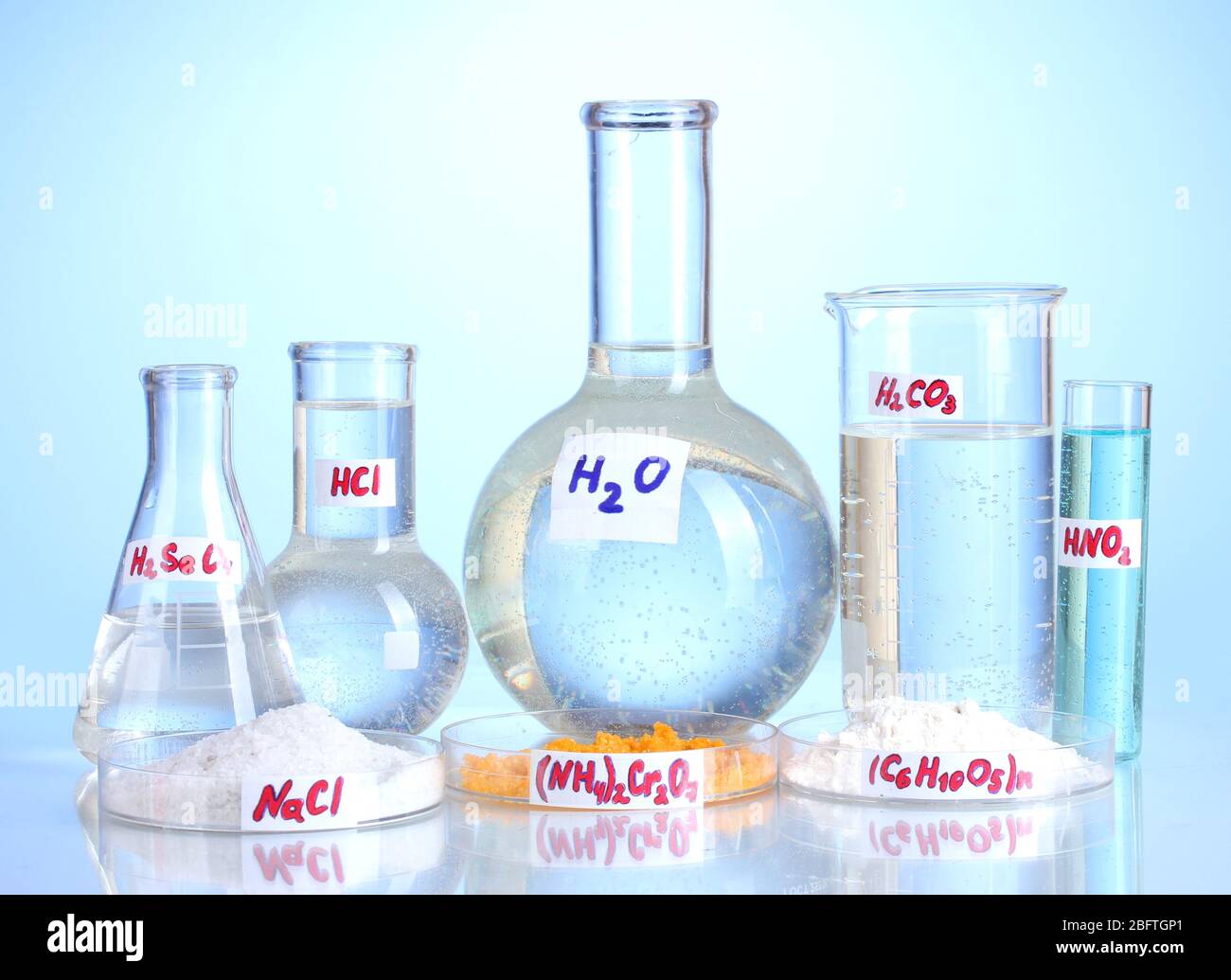 Test-tubes with various acids and chemicals on blue background Stock ...