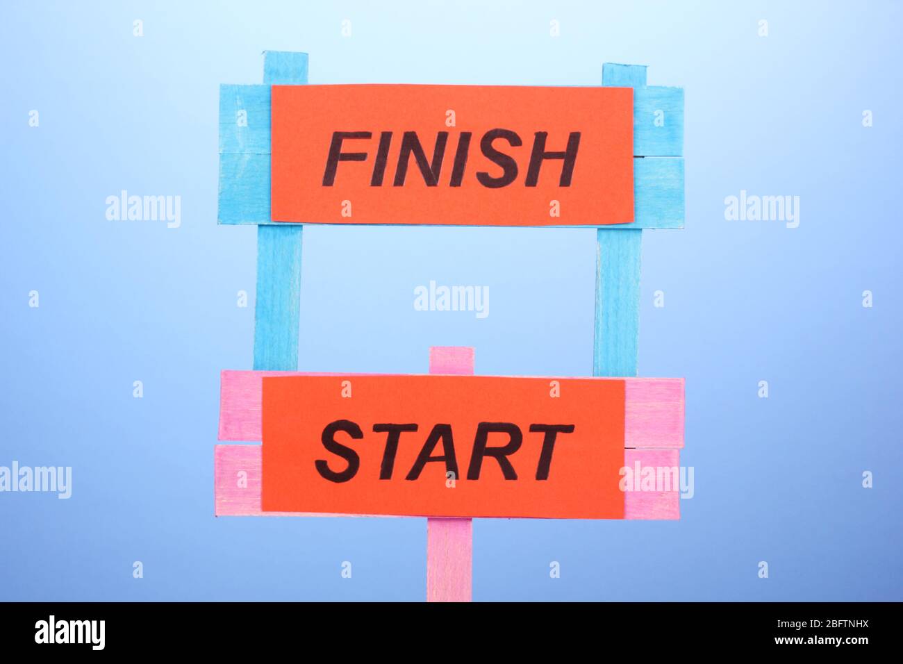 Start, finish wooden boards on blue background Stock Photo - Alamy