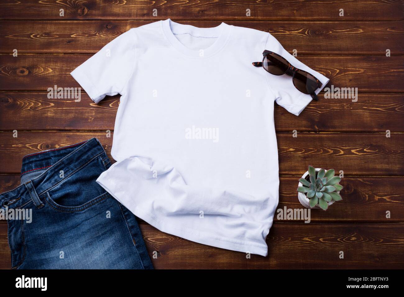 White unisex cotton T-shirt rustic mockup with sunglasses, jeans and succulent plant. Design t shirt template, tee print presentation mock up Stock Photo