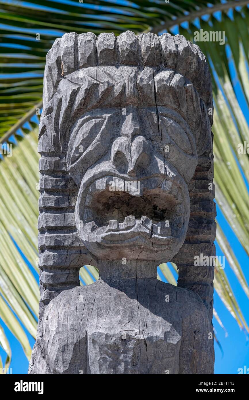 Guardian figure Tiki in front of palm leaf, Pu'uhonua O Honaunau