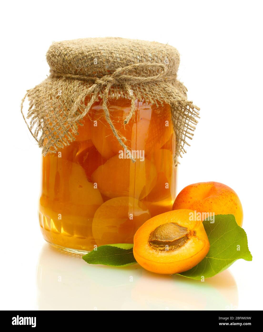 canned apricots in a jar and sweet apricots isolated on white Stock
