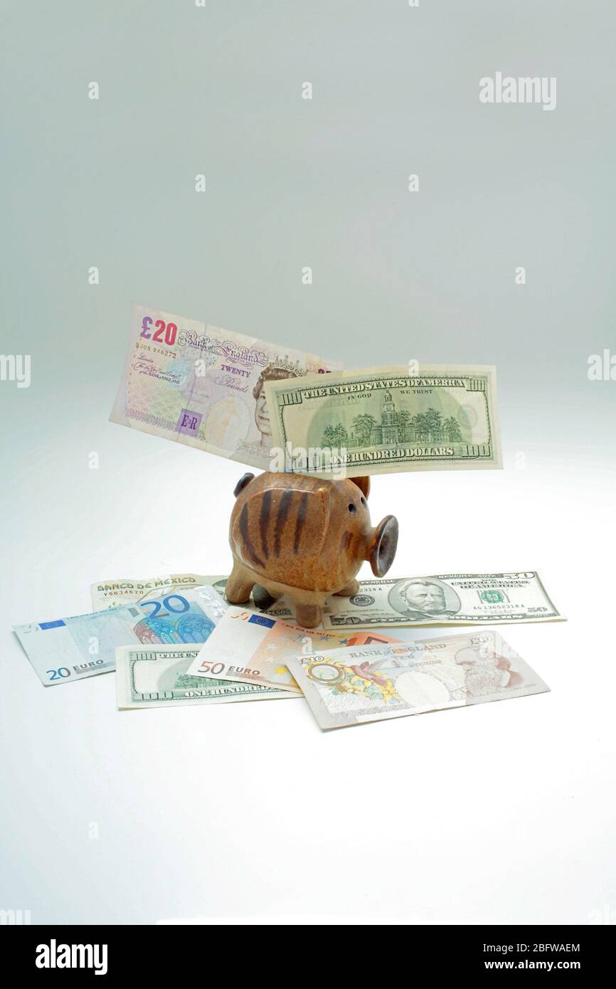 Piggy Bank with bank notes of various nationalities with copy space Stock Photo