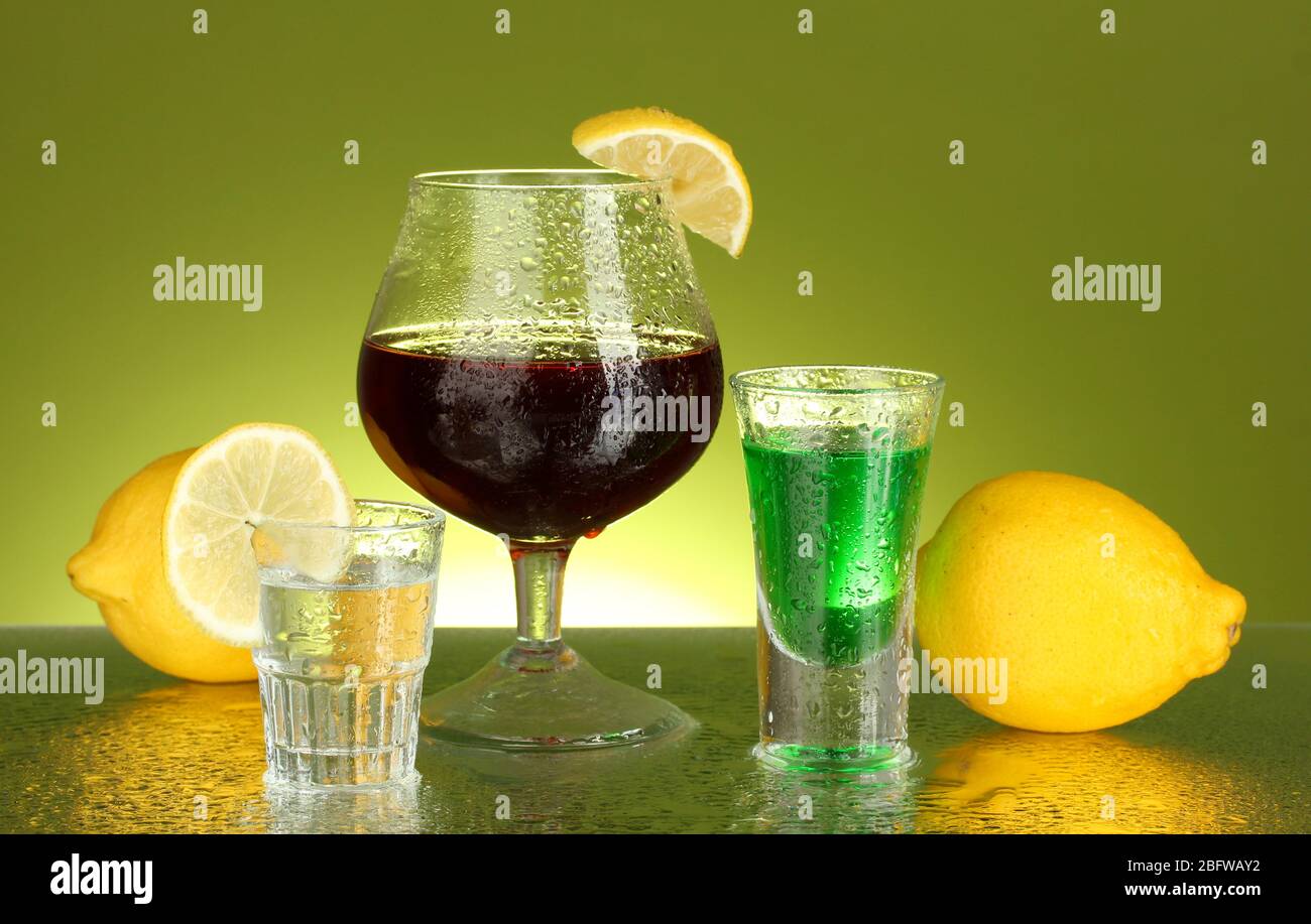 a variety of alcoholic drinks on green background Stock Photo Alamy