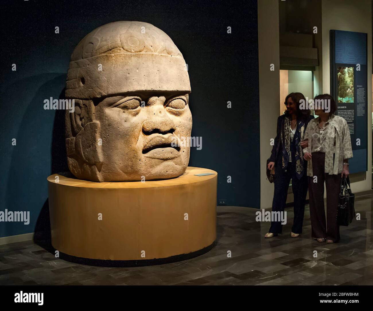 Women looking at Giant Olmec head, Anthropology Museum, Mexico City Mexico Stock Photo