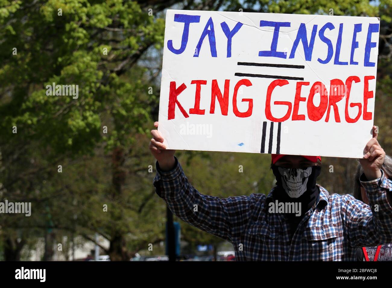 Olympia, United States. 20th Apr, 2017. A man holds a placard comparing Jay Inslee, governor of the state of Washington to George III of the United Kingdom during a protestNearly three thousand protesters took part in a demonstration in the capital calling for an end to Washington's public health lockdown. The demonstration was among one of the largest protests that have erupted in the United States in recent days. Credit: SOPA Images Limited/Alamy Live News Stock Photo