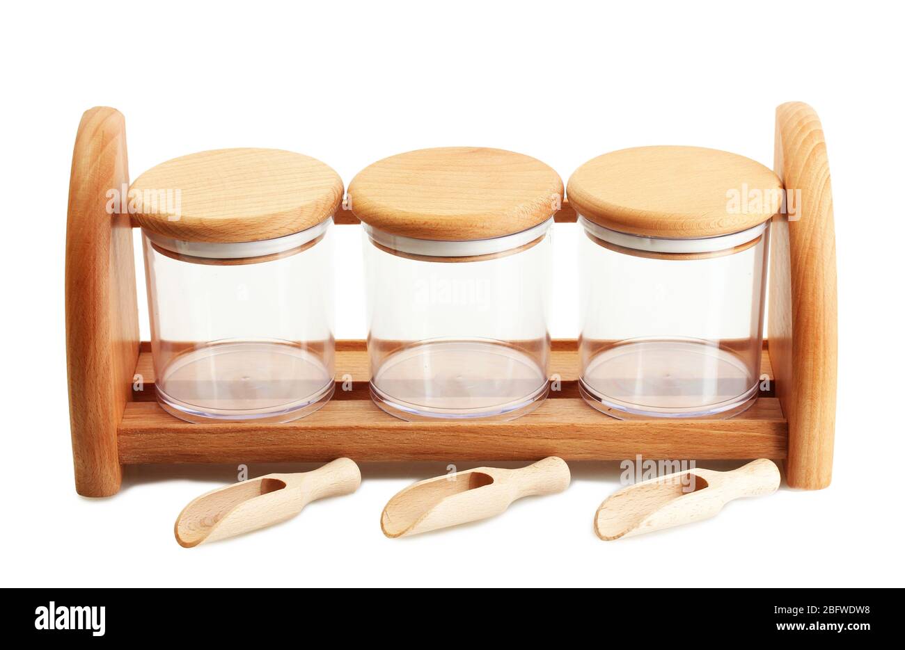 empty glass jars for spices with spoons on wooden shelf isolated on