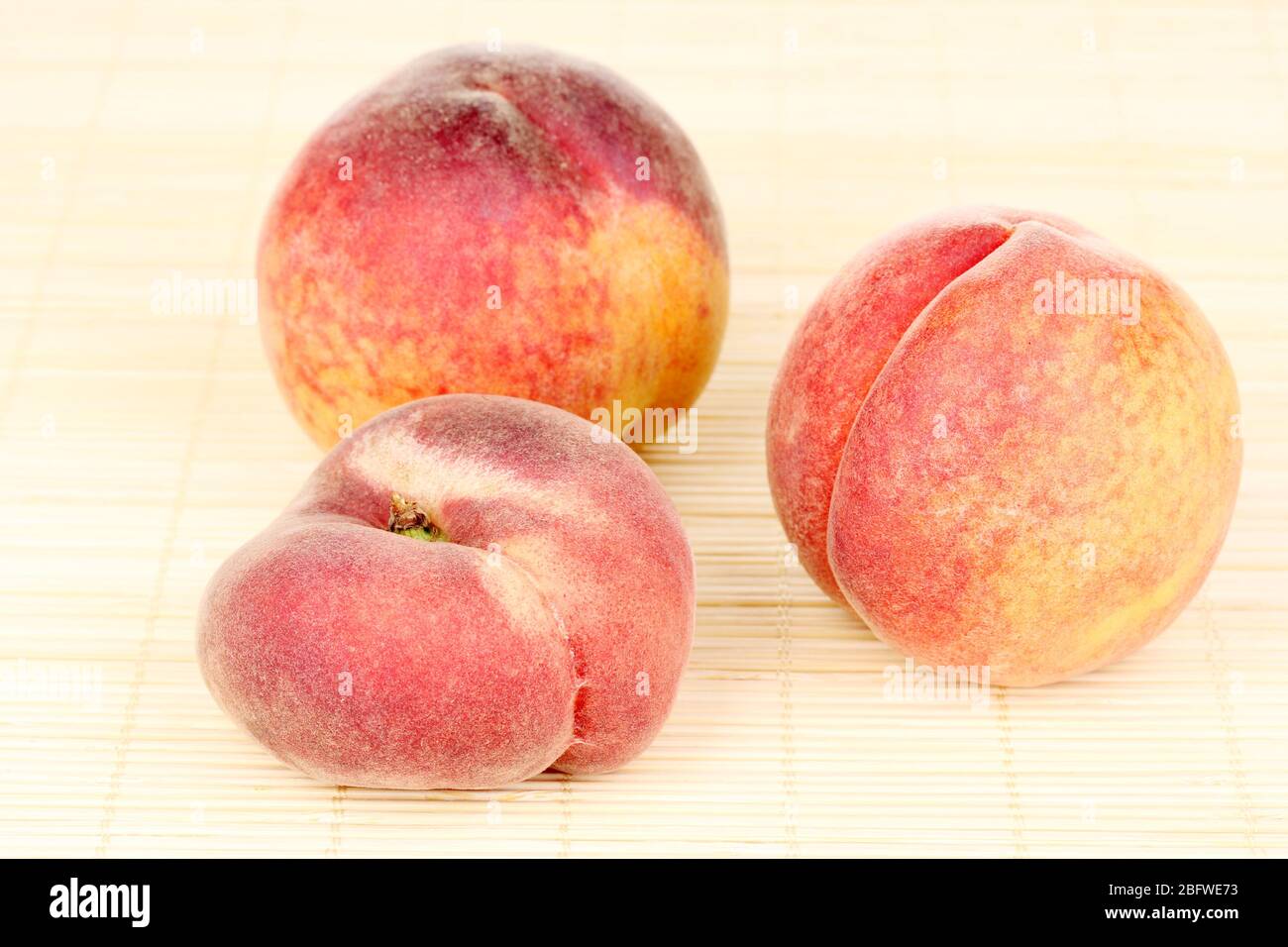 ripe peaches on bamboo mat Stock Photo