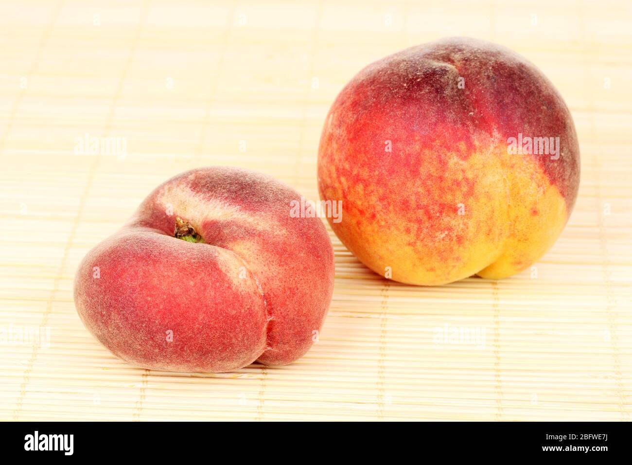 ripe peaches on bamboo mat Stock Photo