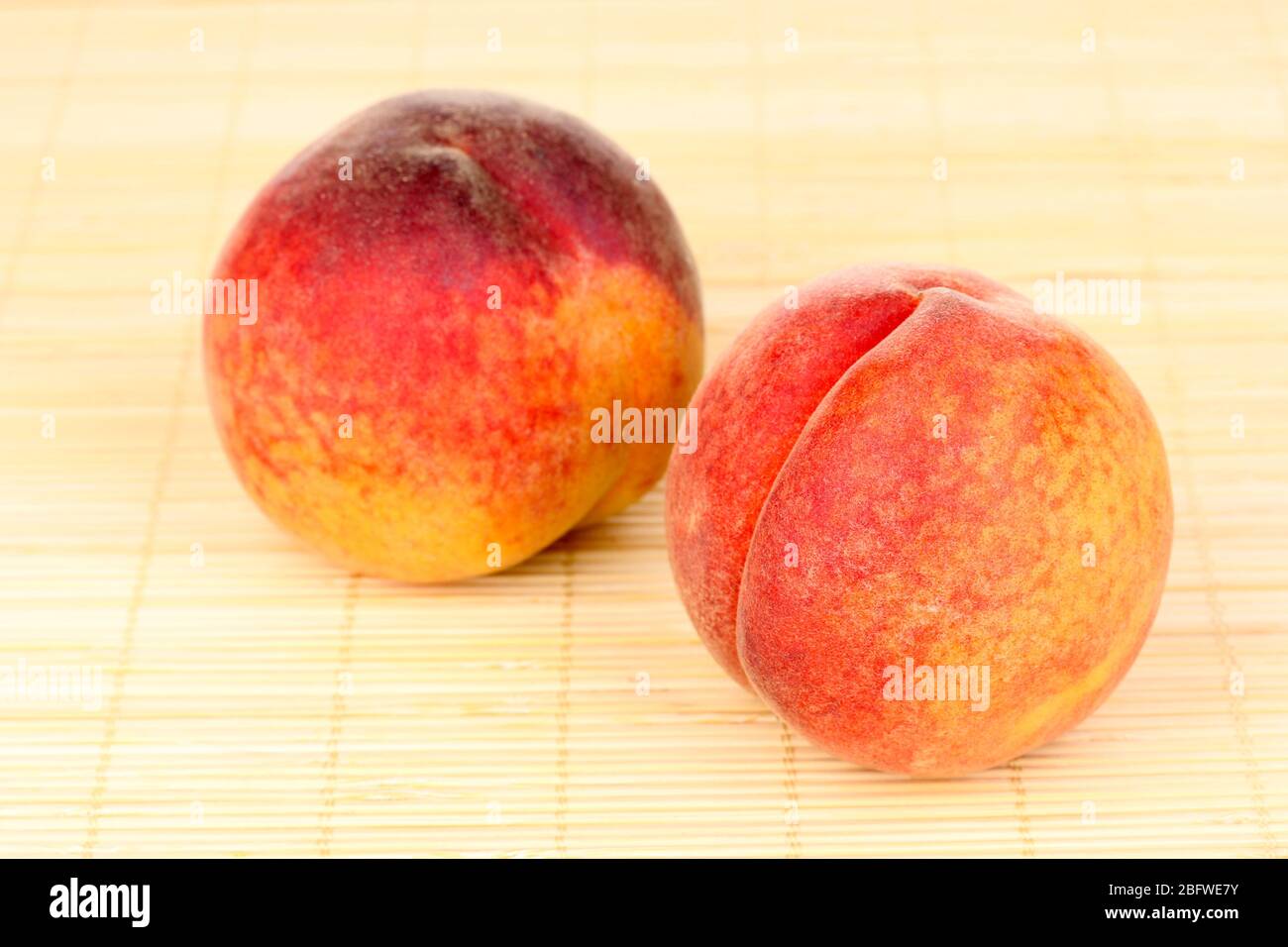 ripe peaches on bamboo mat Stock Photo