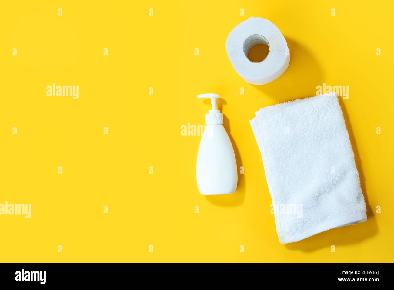 Toilet paper roll, sanitizer antiseptic gel liquid soap on yellow ...