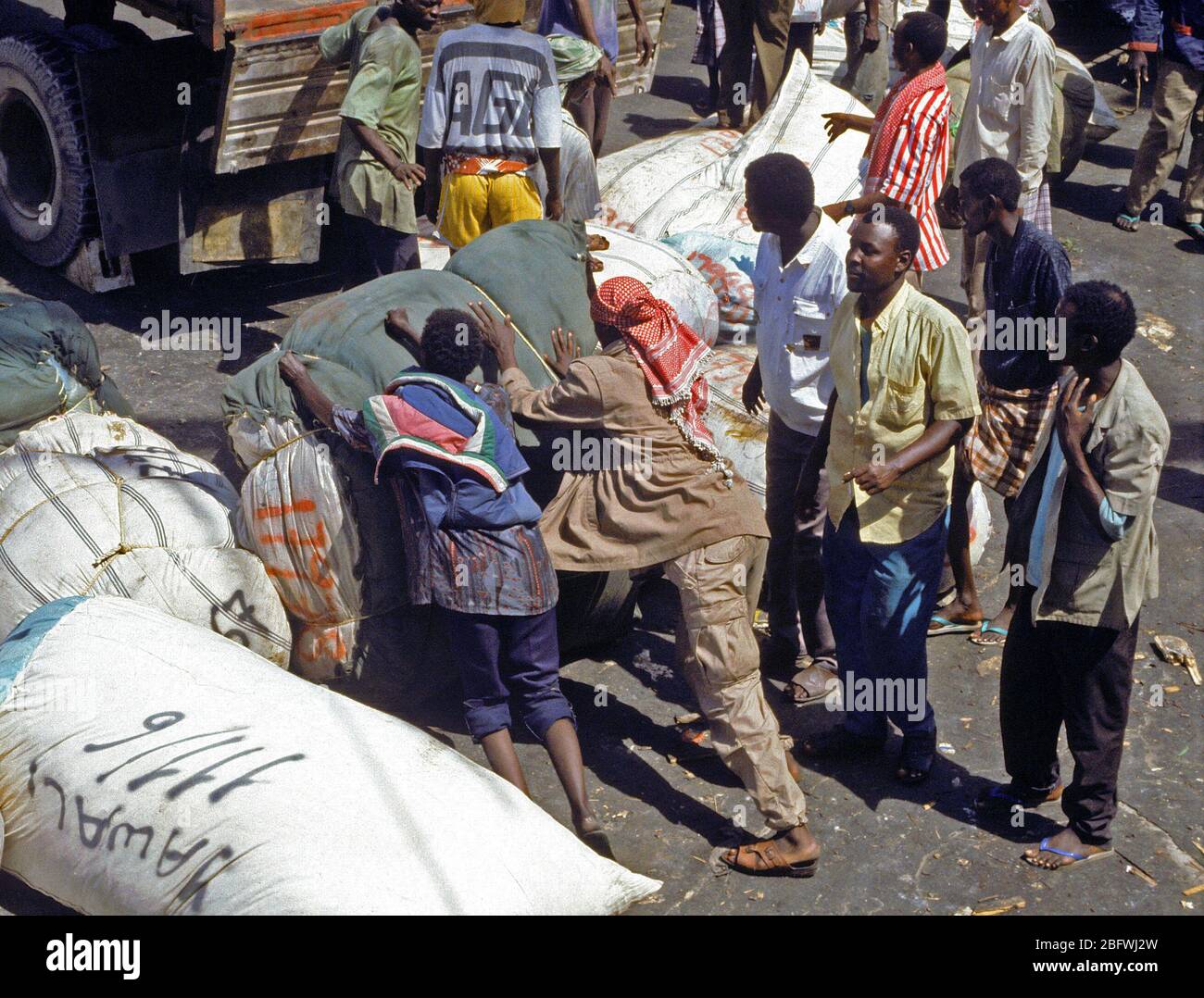 1993 - Somalis off-load rice and other relief supplies from a Saudi Arabian freighter at the seaport.  The Saudis are providing relief supplies to the Somalis under the auspices of UNOSOM II. Stock Photo