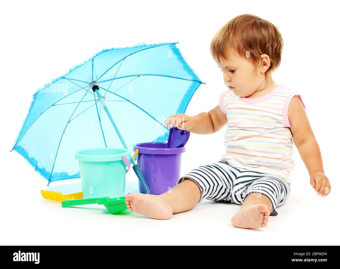 Cute baby with bucket and spade near umbrella isolated on white Stock