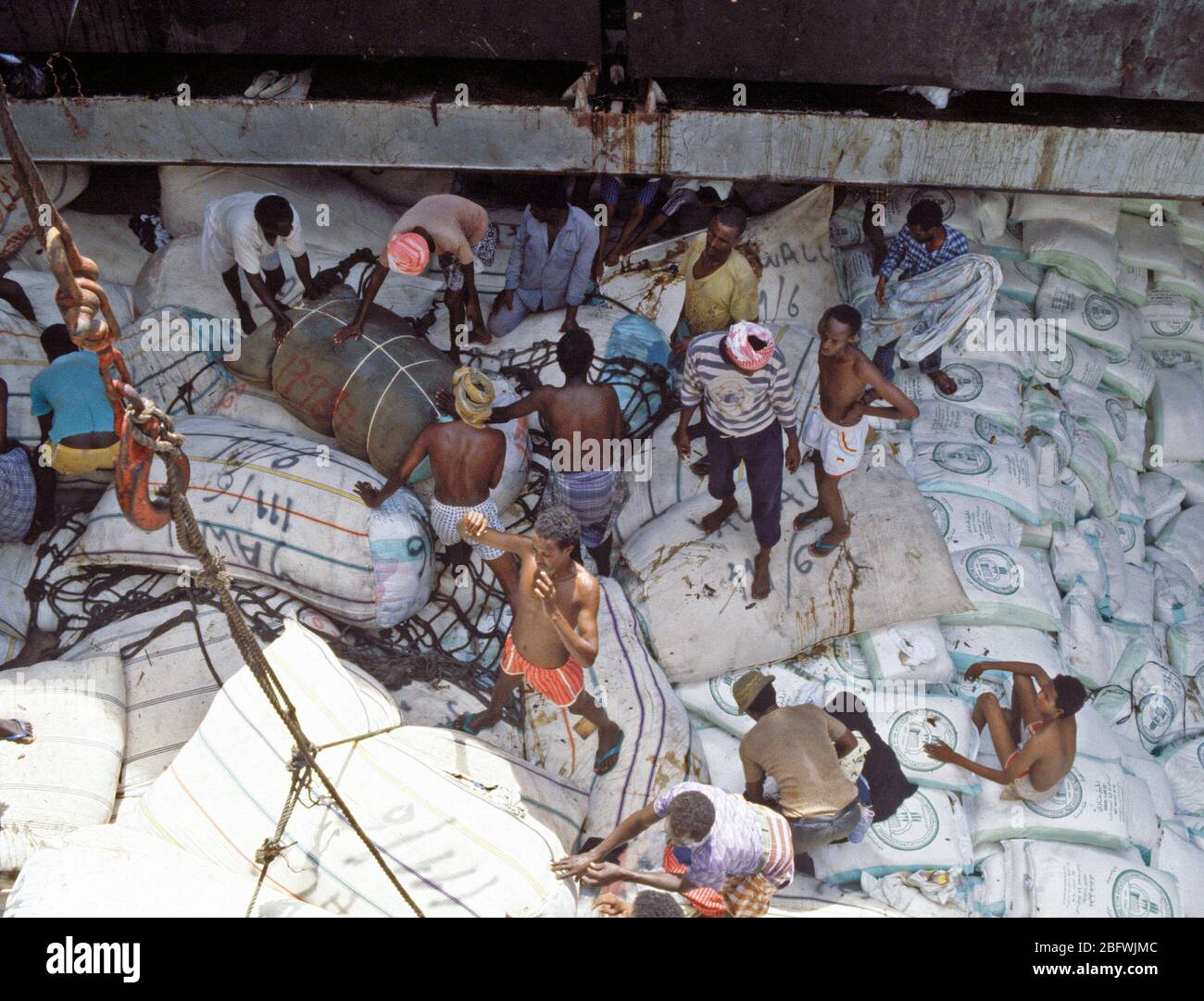1993 - Rice and other relief supplies rest in the hold of a Saudi Arabian freighter as Somalis work to off-load at the seaport.  The Saudis are providing relief supplies to the Somali people. Stock Photo