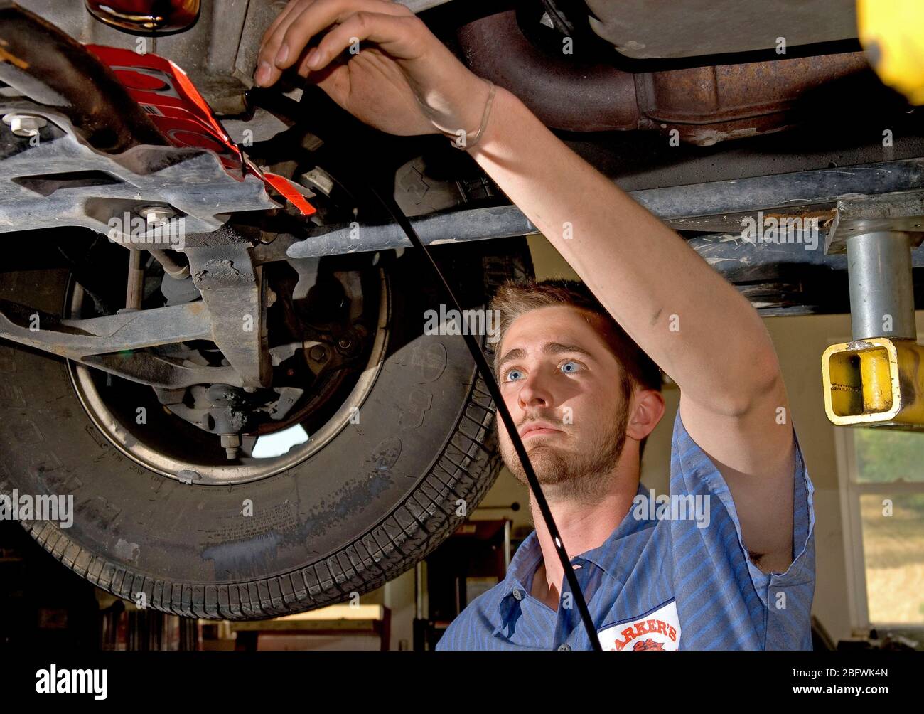 2007 - Mechanic in Maryland providing routine maintainance by draining motor oil from a car during an oil change Stock Photo