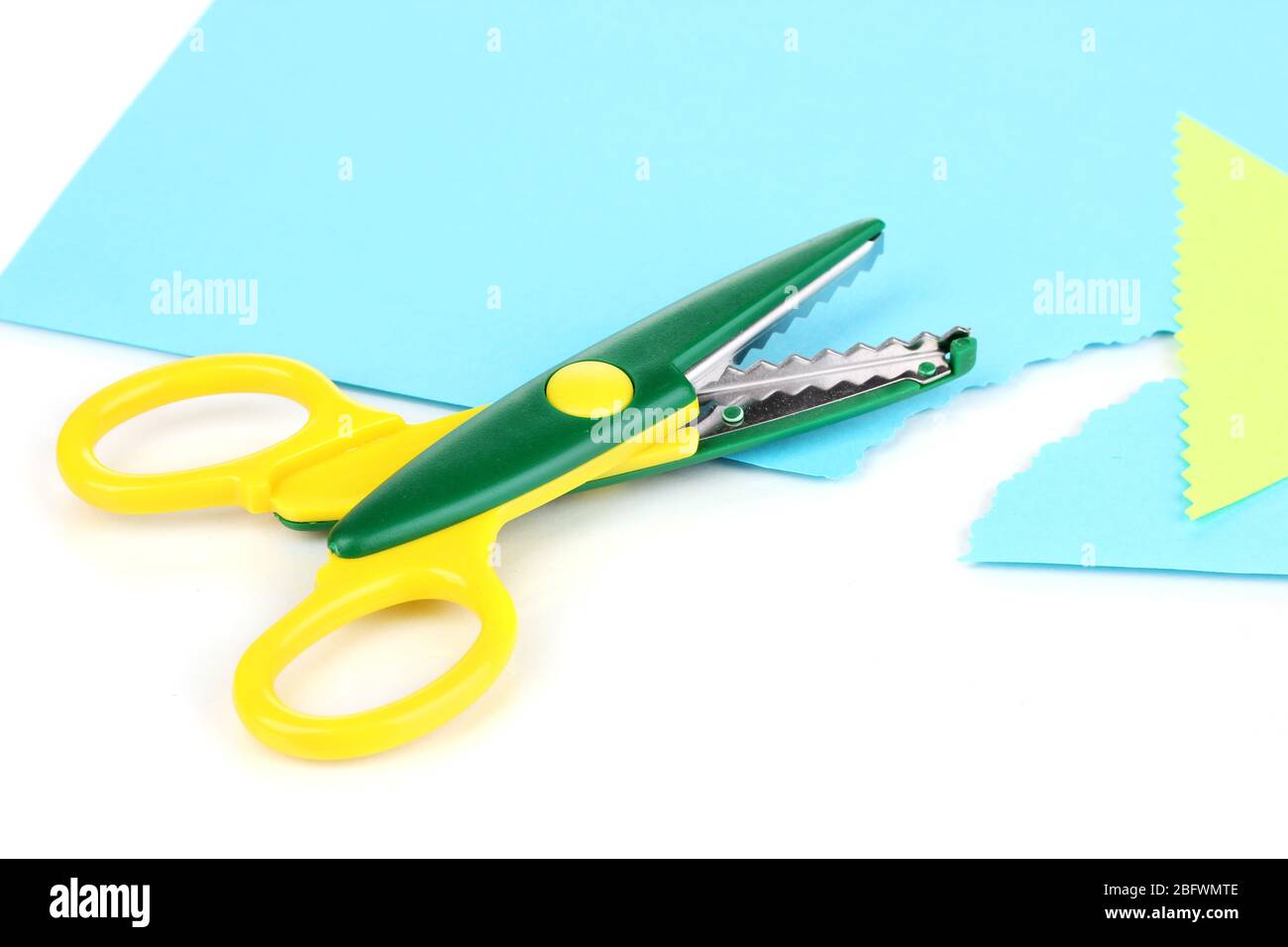 Colorful zigzag scissors with color paper isolated on white Stock Photo