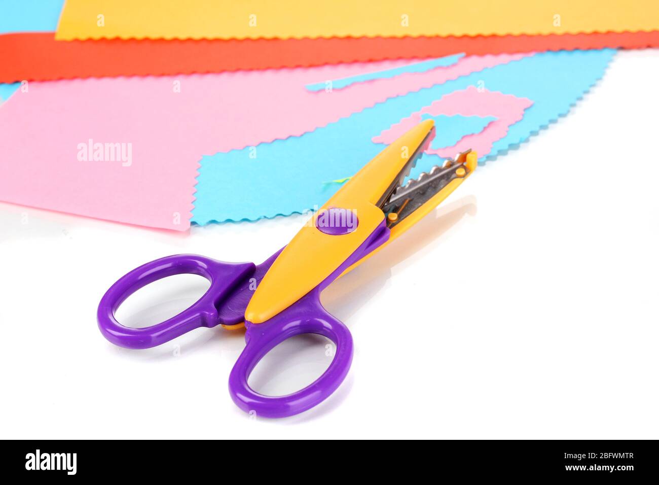 Colorful zigzag scissors with color paper isolated on white Stock Photo