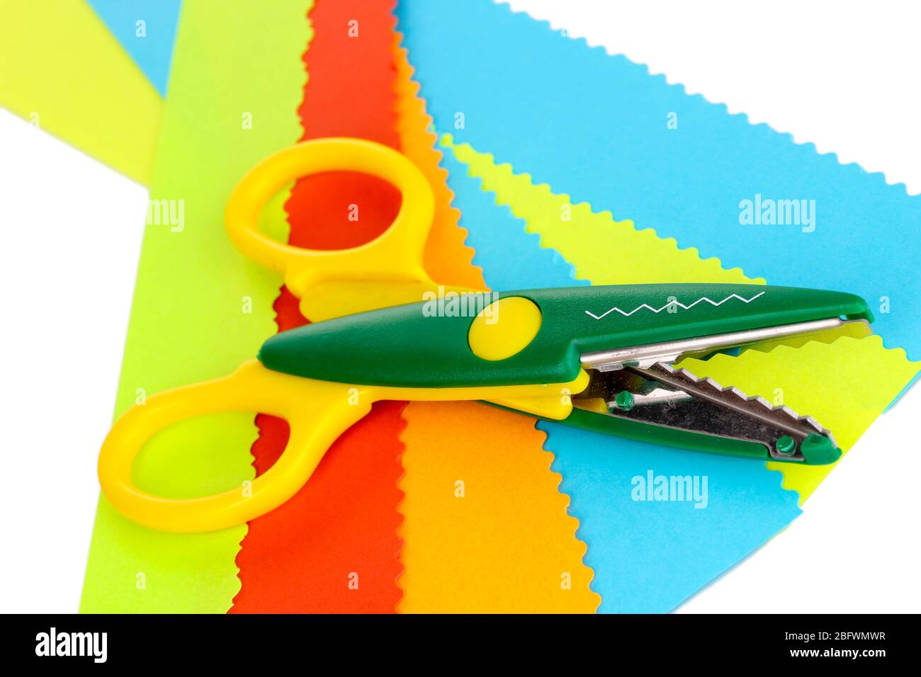 Colorful zigzag scissors with color paper isolated on white Stock Photo