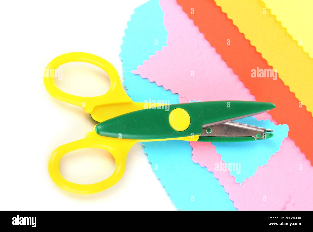 Colorful zigzag scissors with color paper isolated on white Stock Photo
