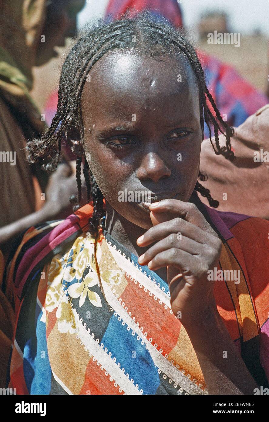 1993 - A Somali girl watches U.S. personnel during the multinational relief effort Operation Restore Hope. Stock Photo
