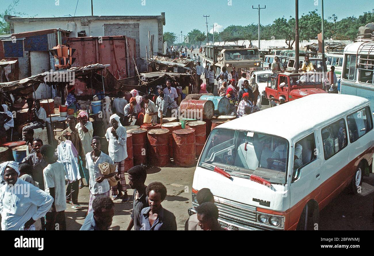 1992 - People and vehicles crowd a street corner during the multinational relief effort Operation Restore Hope. (Mogadishu Somalia) Stock Photo