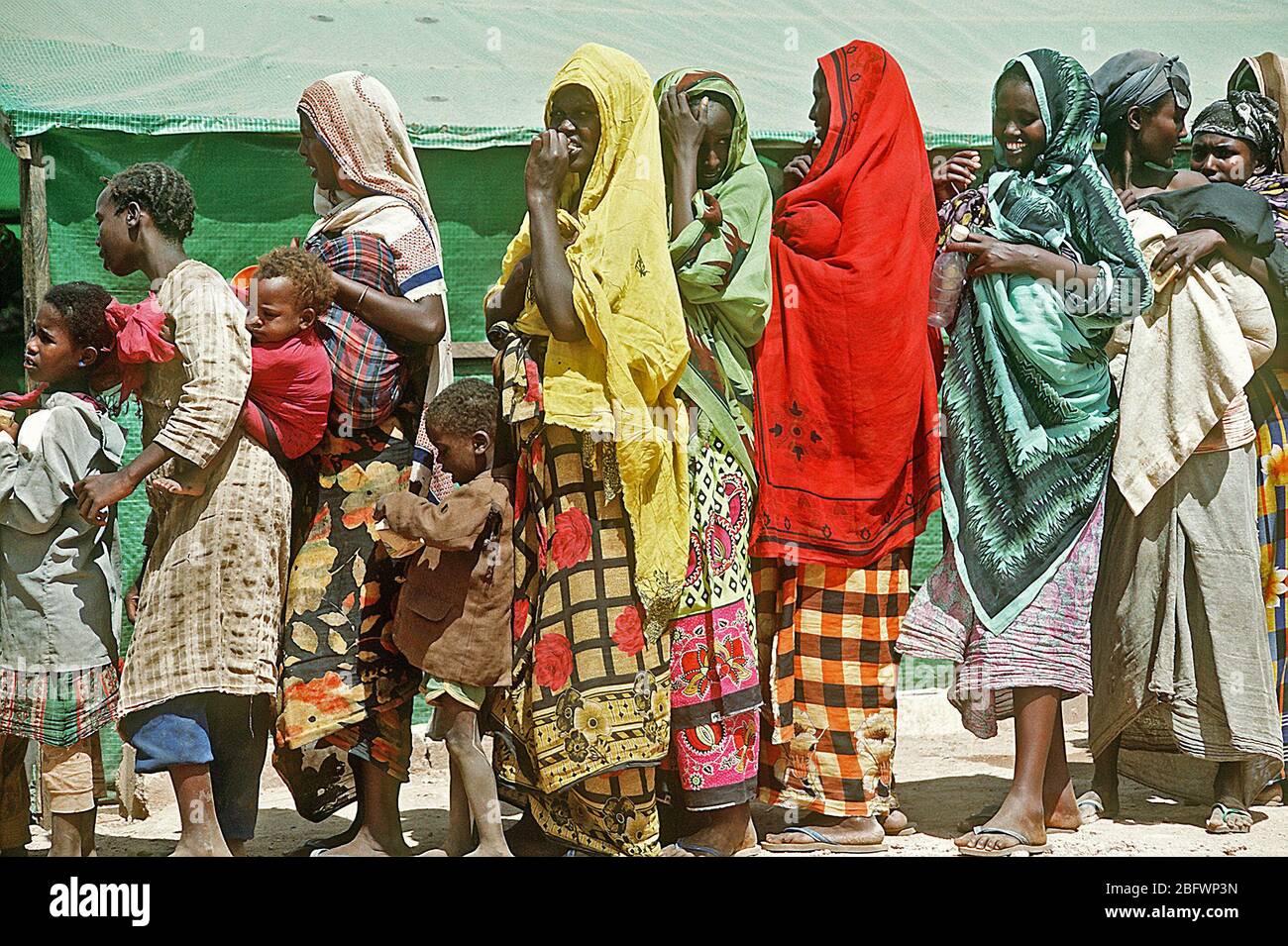 1993 -Somali women and children line up at an aid station during the multinational relief effort Operation Restore Hope. Stock Photo
