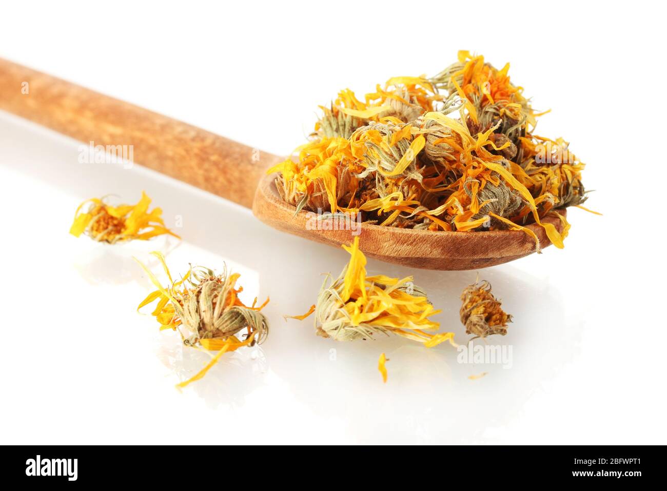 dried calendula flowers in wooden spoon, isolated on white Stock Photo ...