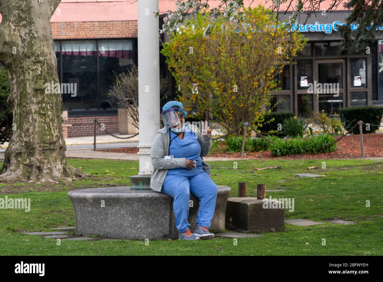 New York, United States. 19th Apr, 2020. A nurse wearing a personal protective equipment (PPE) takes a break outside the Coler Hospital campus at Roosevelt Island amid the coronavirus (covid-19) pandemic in New York City. Coler Hospital, which was closed in 2018, is being looked at by New York City as a location to expand hospital facilities to treat coronavirus patients. Credit: SOPA Images Limited/Alamy Live News Stock Photo