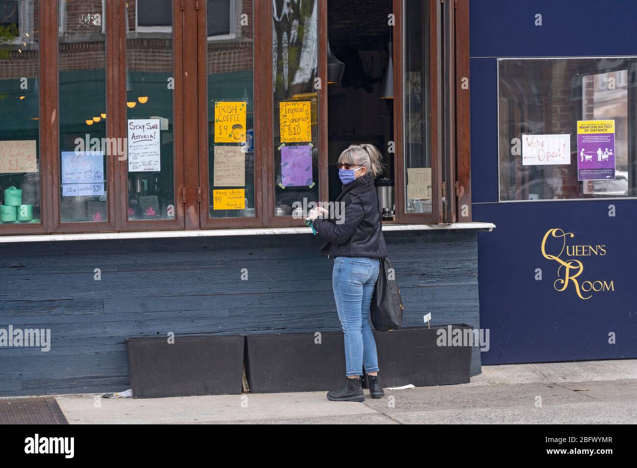 Astoria, United States. 19th Apr, 2020. A customer waits for an order outsides the Queen's Room amid the coronavirus (covid-19) pandemic in New York City. Credit: SOPA Images Limited/Alamy Live News Stock Photo