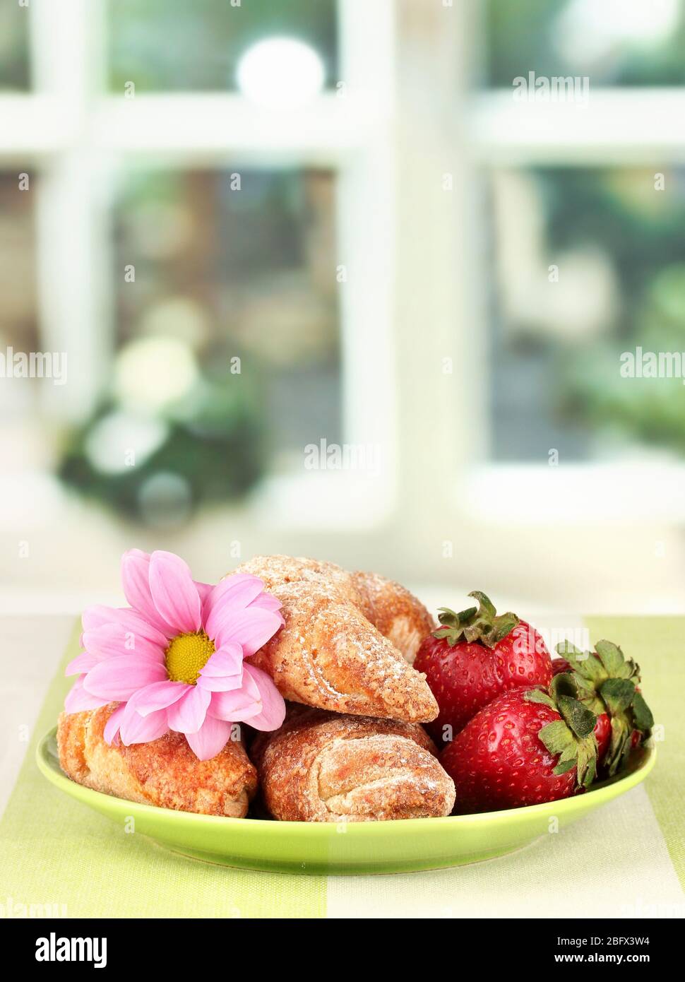 Fresh bagels with strawberry in the plate on the table Stock Photo