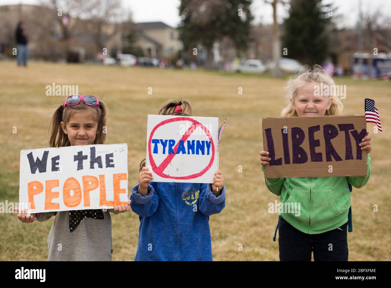 Helena, Montana - April 19, 2020: Children, young girls, holding liberty and tyranny sign at the protest rally at the Capitol due to the government sh Stock Photo