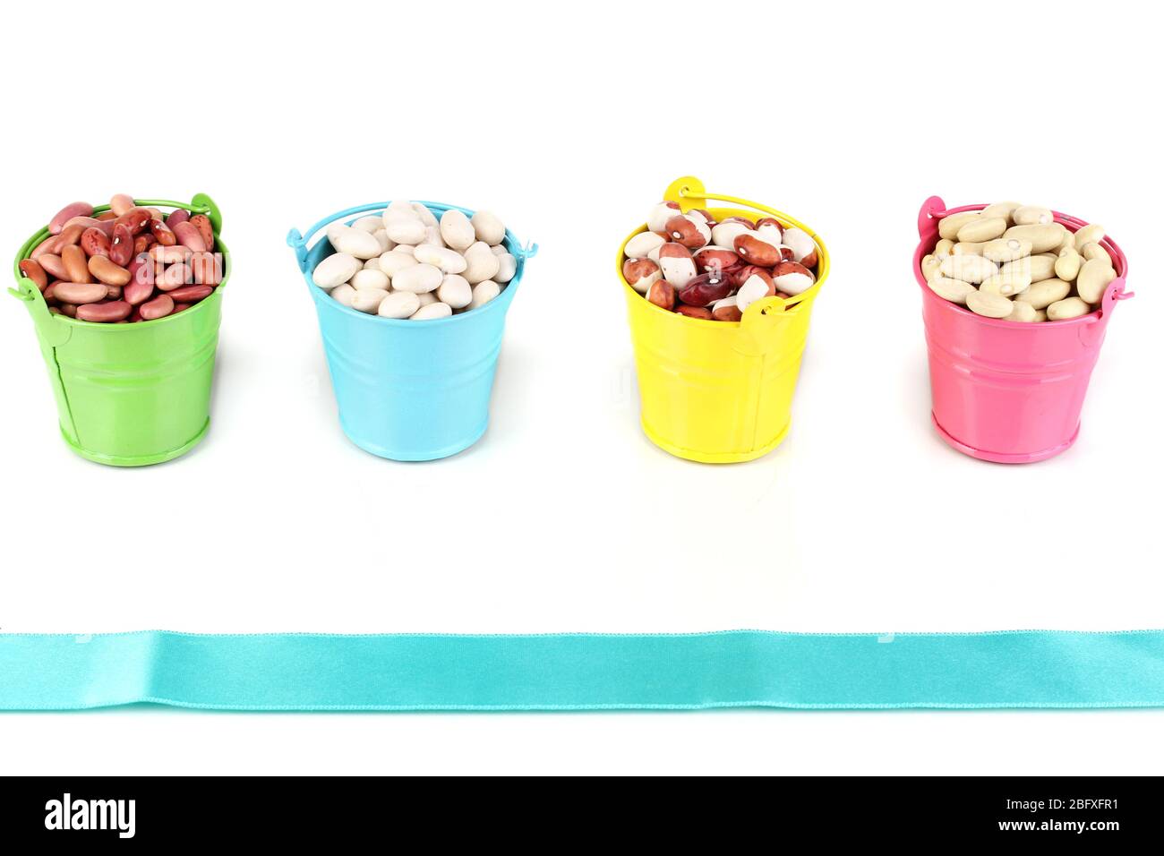 Different types of beans in colored buckets isolated on white Stock
