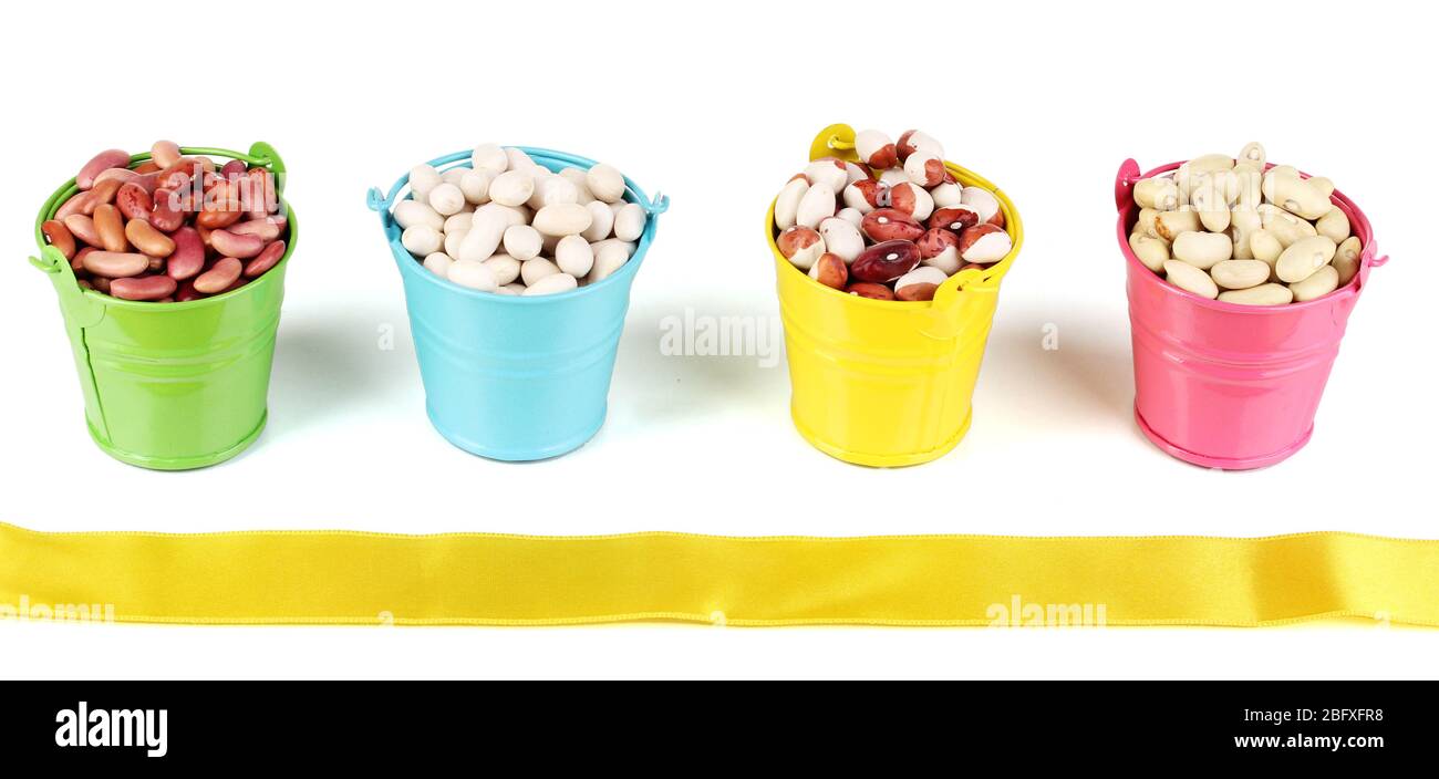 Different types of beans in colored buckets isolated on white Stock