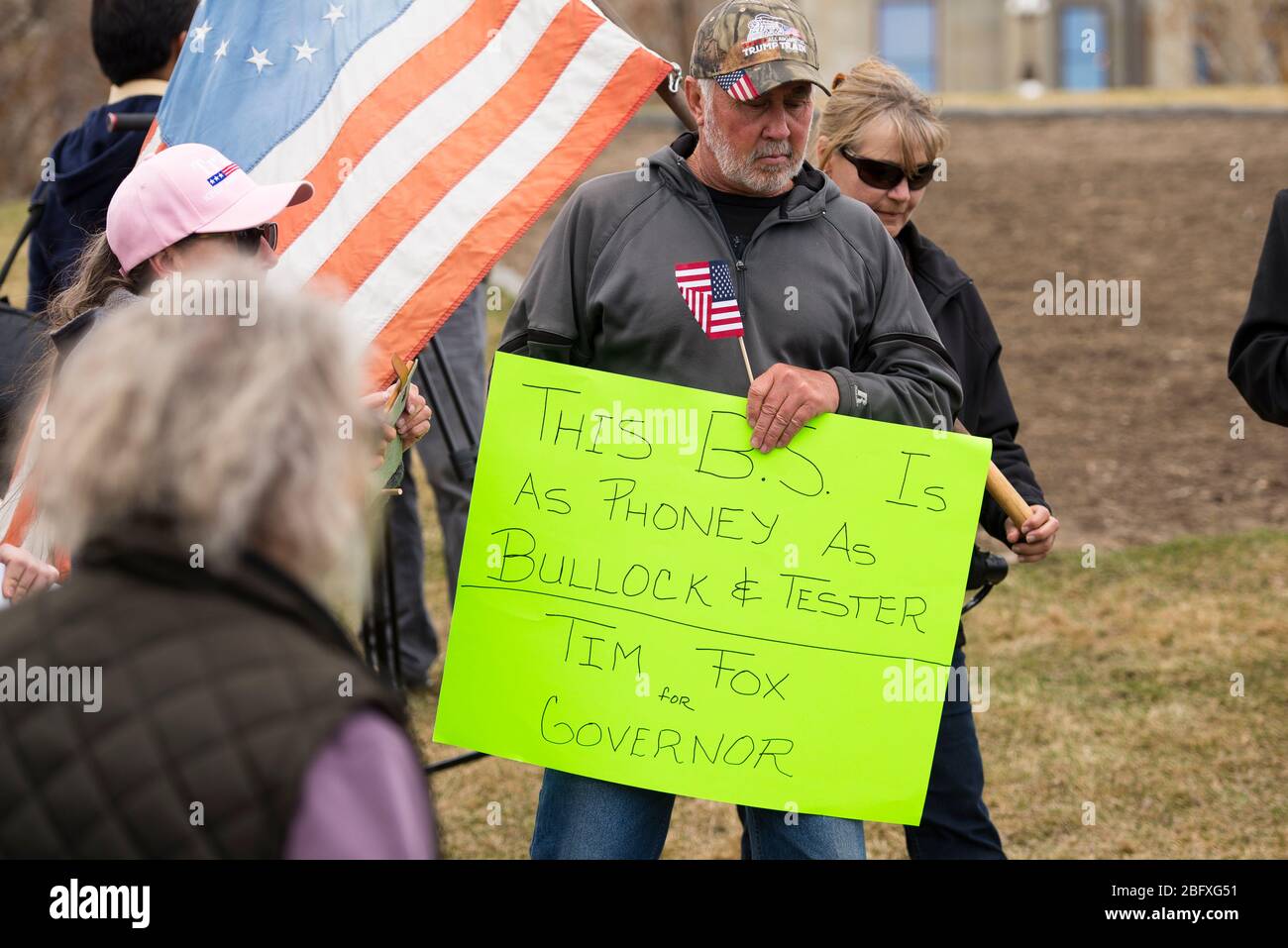 Helena, Montana - April 19, 2020: A demonstrator holds a neon sign in dislike of the governor at a protest of the government shutdown at the Capitol. Stock Photo