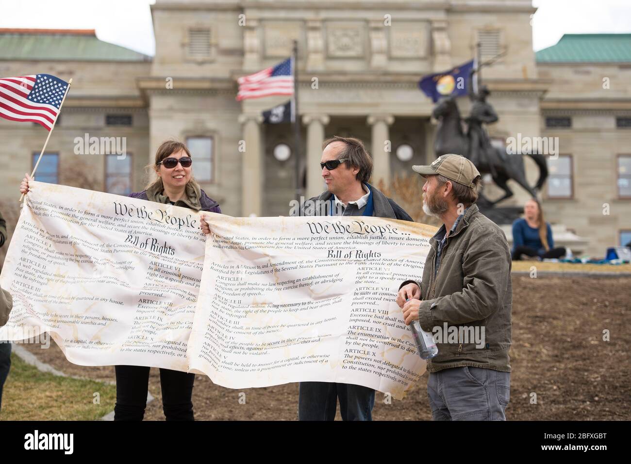 Helena, Montana - April 19, 2020: A man an woman protestor holding banners of the Bill of Rights in front of the Capitol building at a protest of the Stock Photo