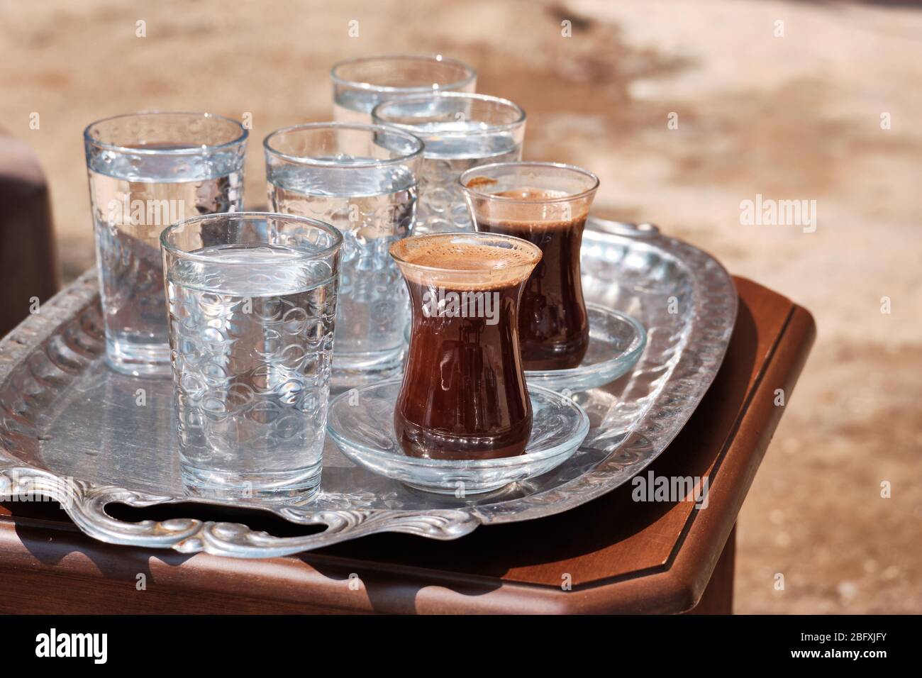 Glasses of water and Turkish coffee are on a metal tray Stock Photo - Alamy