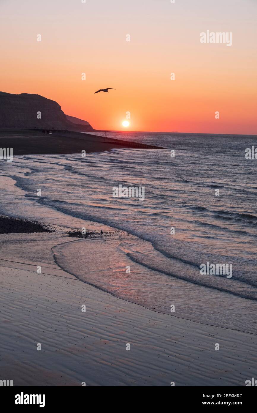 Hastings, East Sussex, 20th April 2020. Clear sunrise at low tide at the harbour on a chilly morning, but with another fine sunny day in prospect. Carolyn Clarke/Alamy Live News Stock Photo
