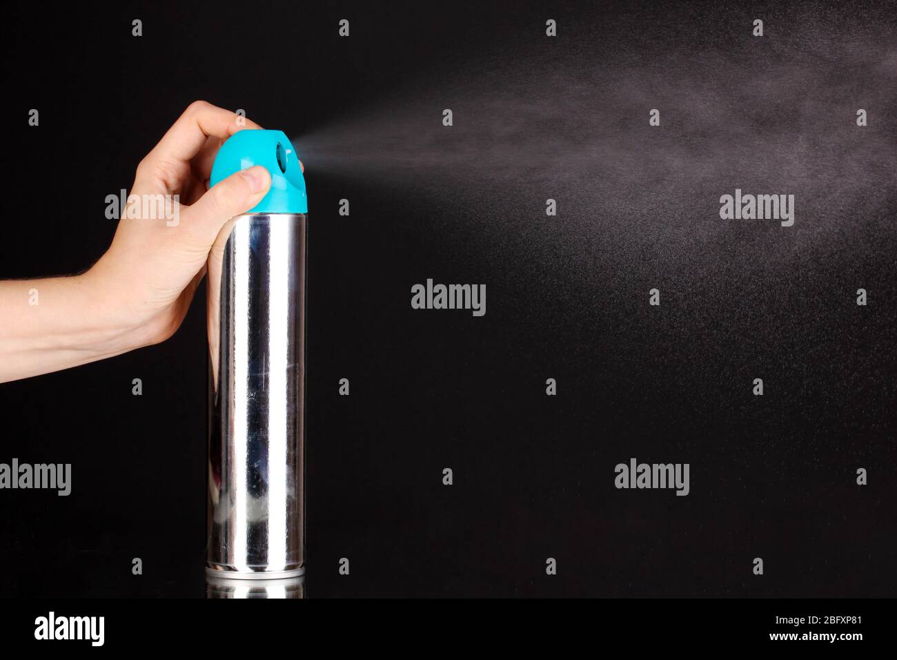 Sprayed air freshener in hand isolated on black Stock Photo Alamy