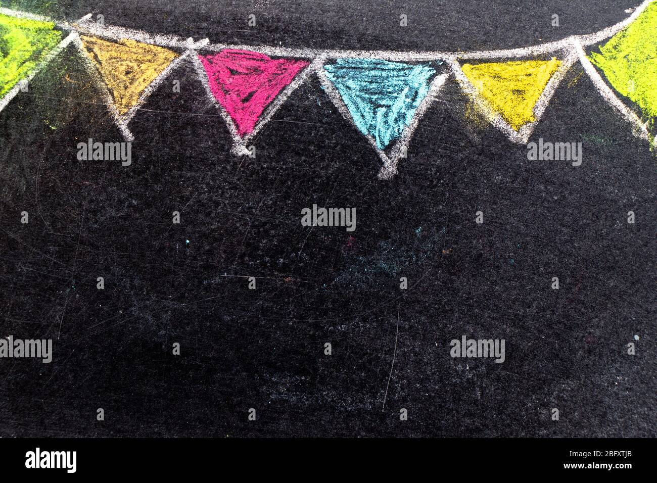 Colorful chalk drawing in hanging party flag shape on blackboard