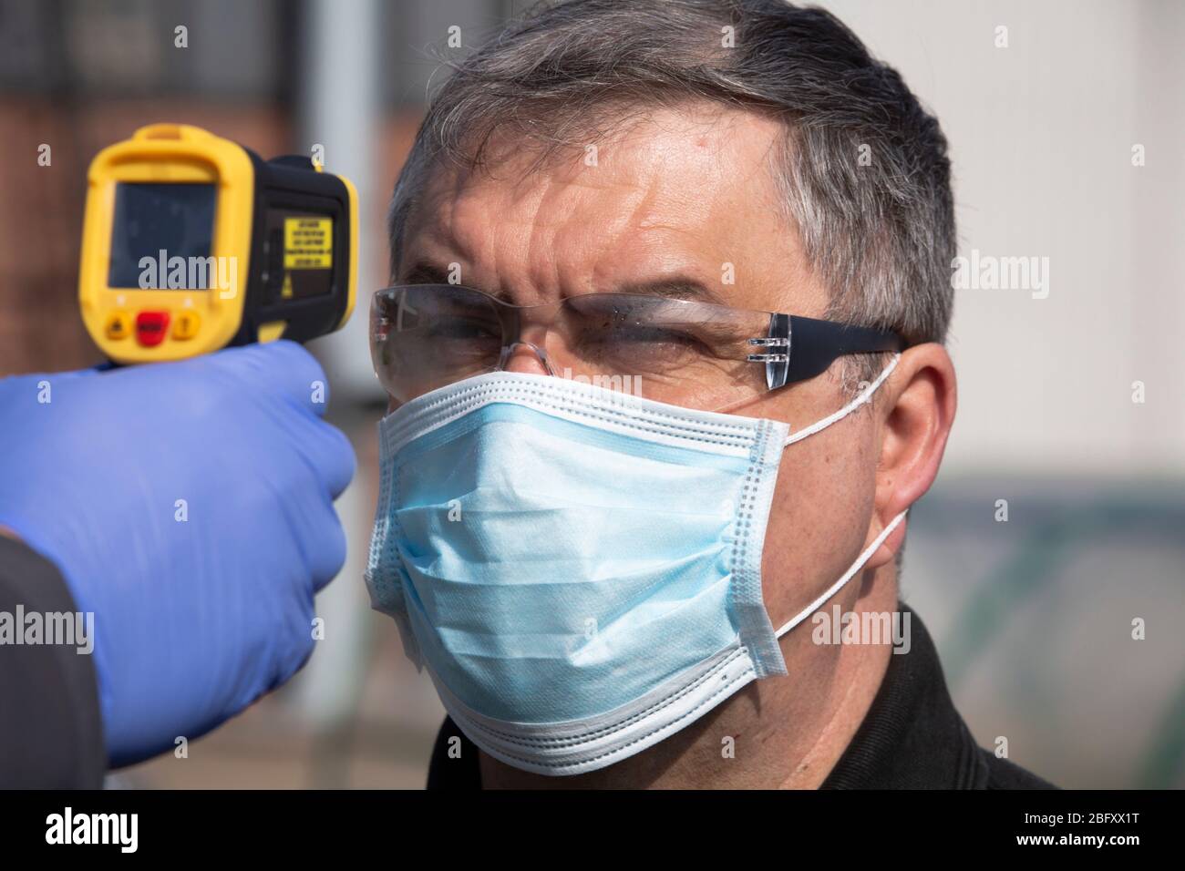 A member of staff at the Vauxhall car factory photographed having his temperature read during preparedness tests and redesign ahead of re-opening following the COVID-19 outbreak. Located in Ellesmere Port, Wirral, the factory opened in 1962 and currently employs around 1100 workers. It ceased production on 17 March 2020 and will only resume work upon the advice of the UK Government, which will involve stringent physical distancing measures being in place across the site. Stock Photo