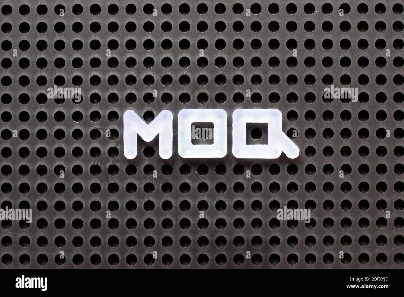 Black color pegboard with white letter in word MOQ (Abbreviation of Minimum Order Quantity Stock