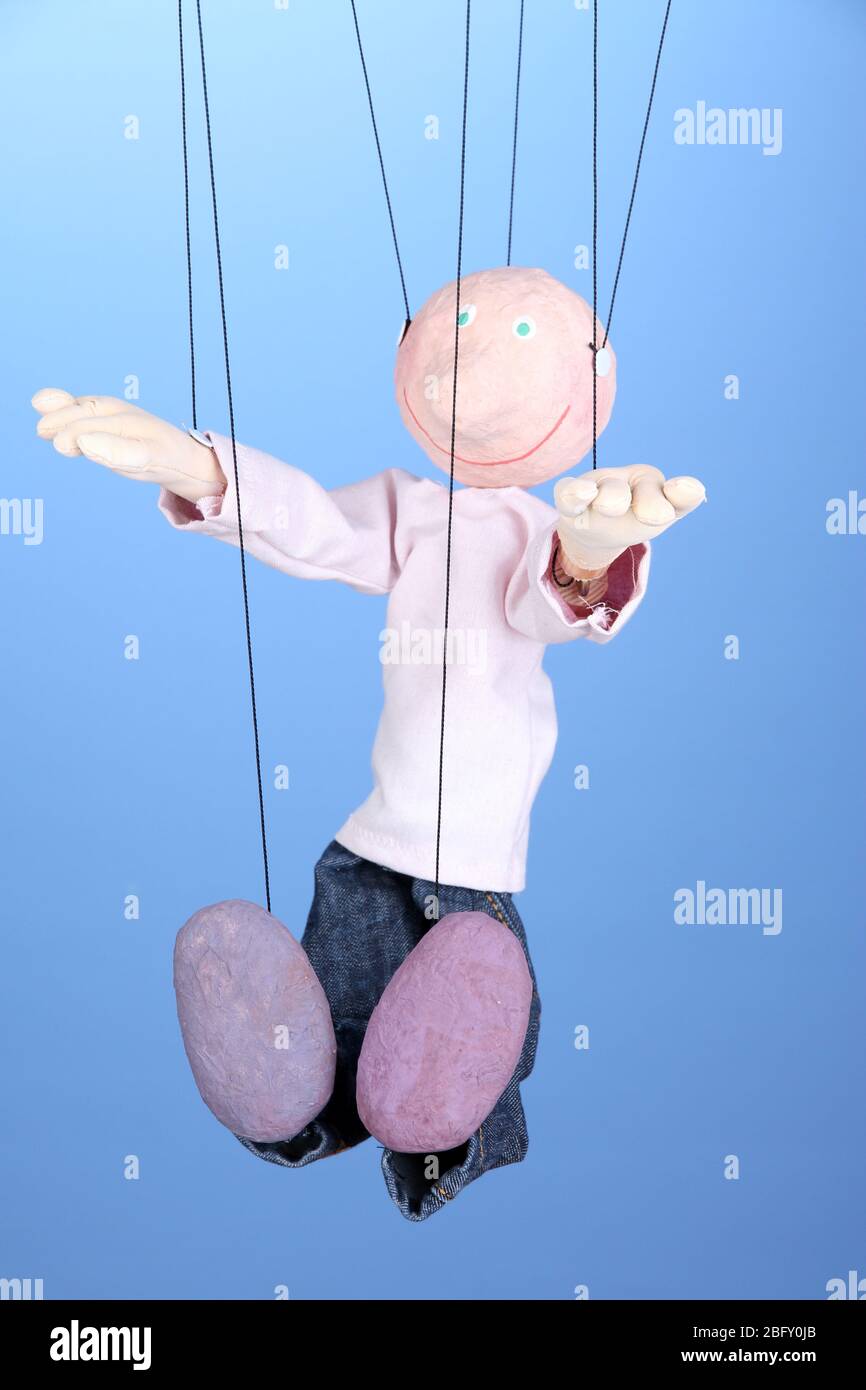 Wooden puppet on blue background Stock Photo - Alamy