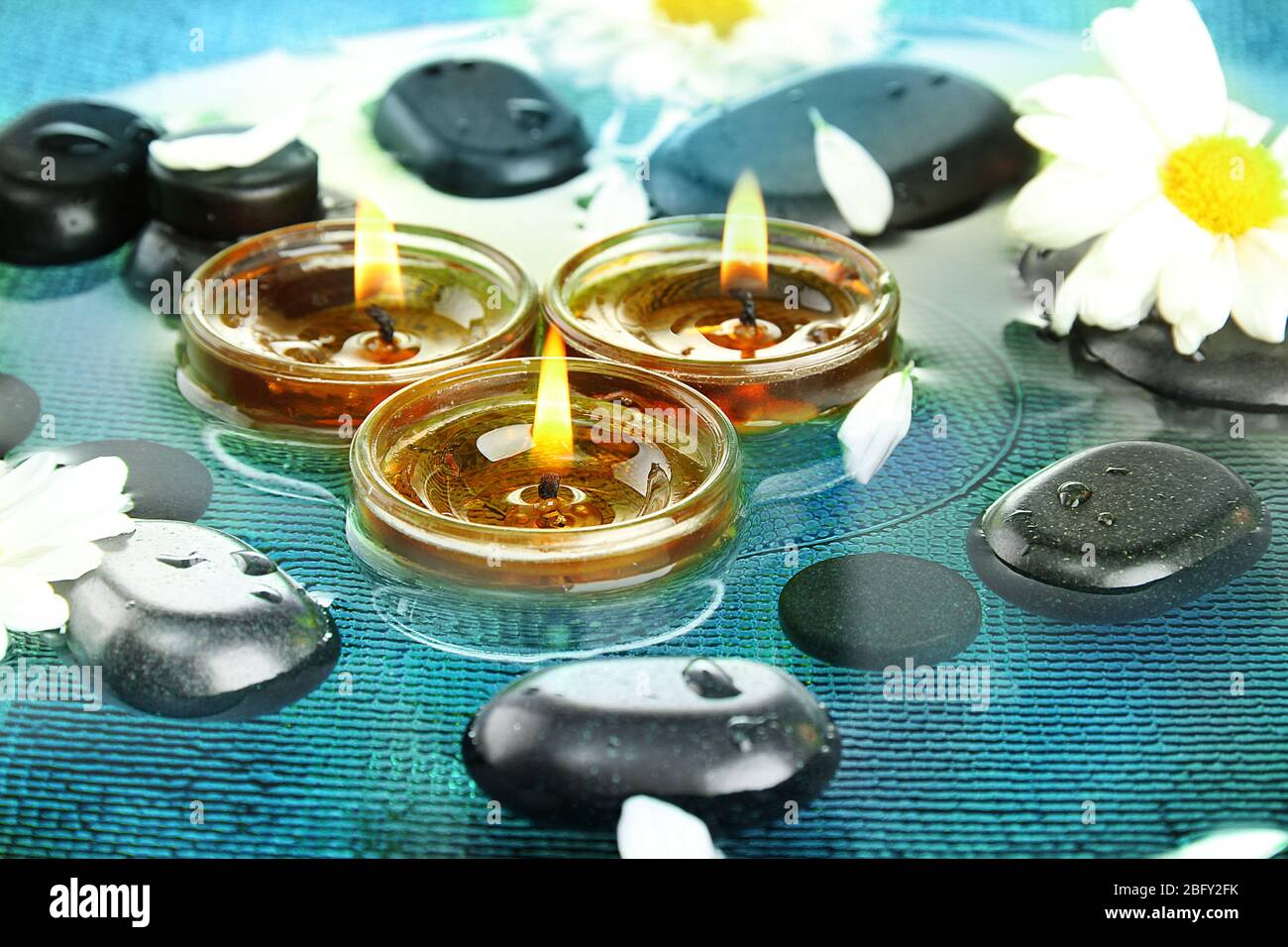 spa stones with flowers and candles in water Stock Photo - Alamy