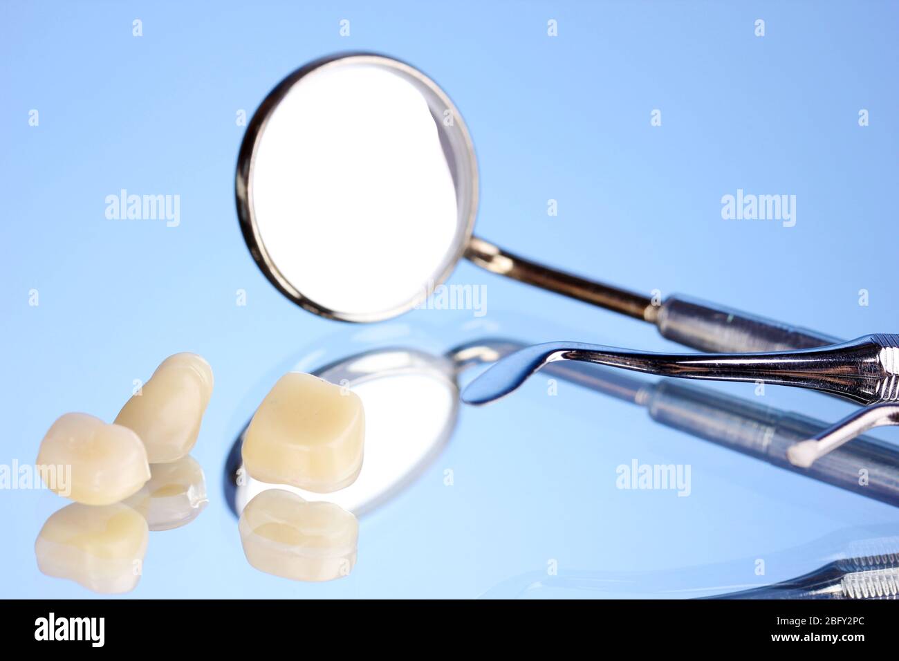 dental mirror with denture teeth on blue background Stock Photo - Alamy