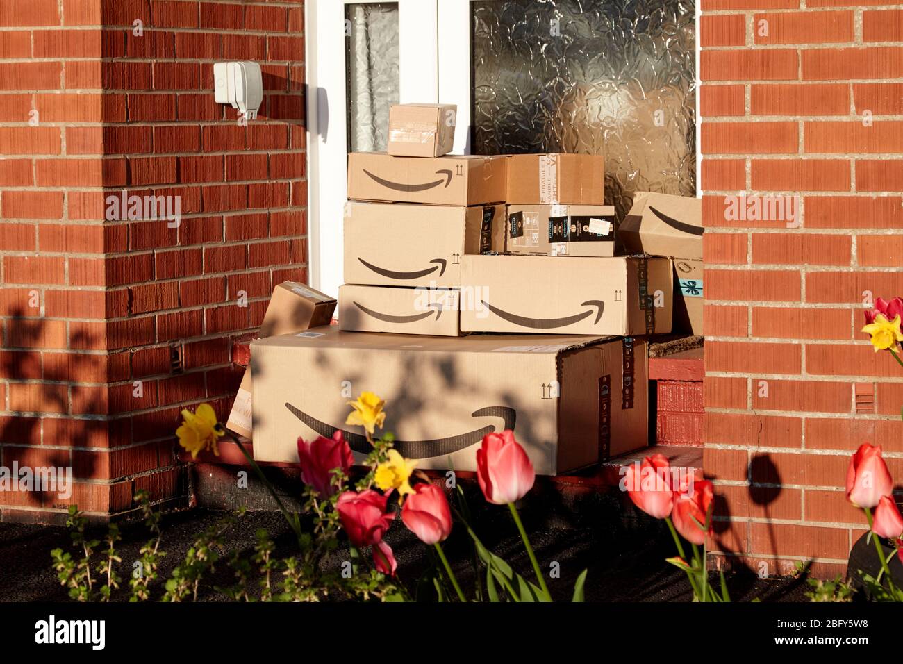 large consignment of amazon deliveries left on doorstep of house during coronavirus covid-19 lockdown in the uk Stock Photo