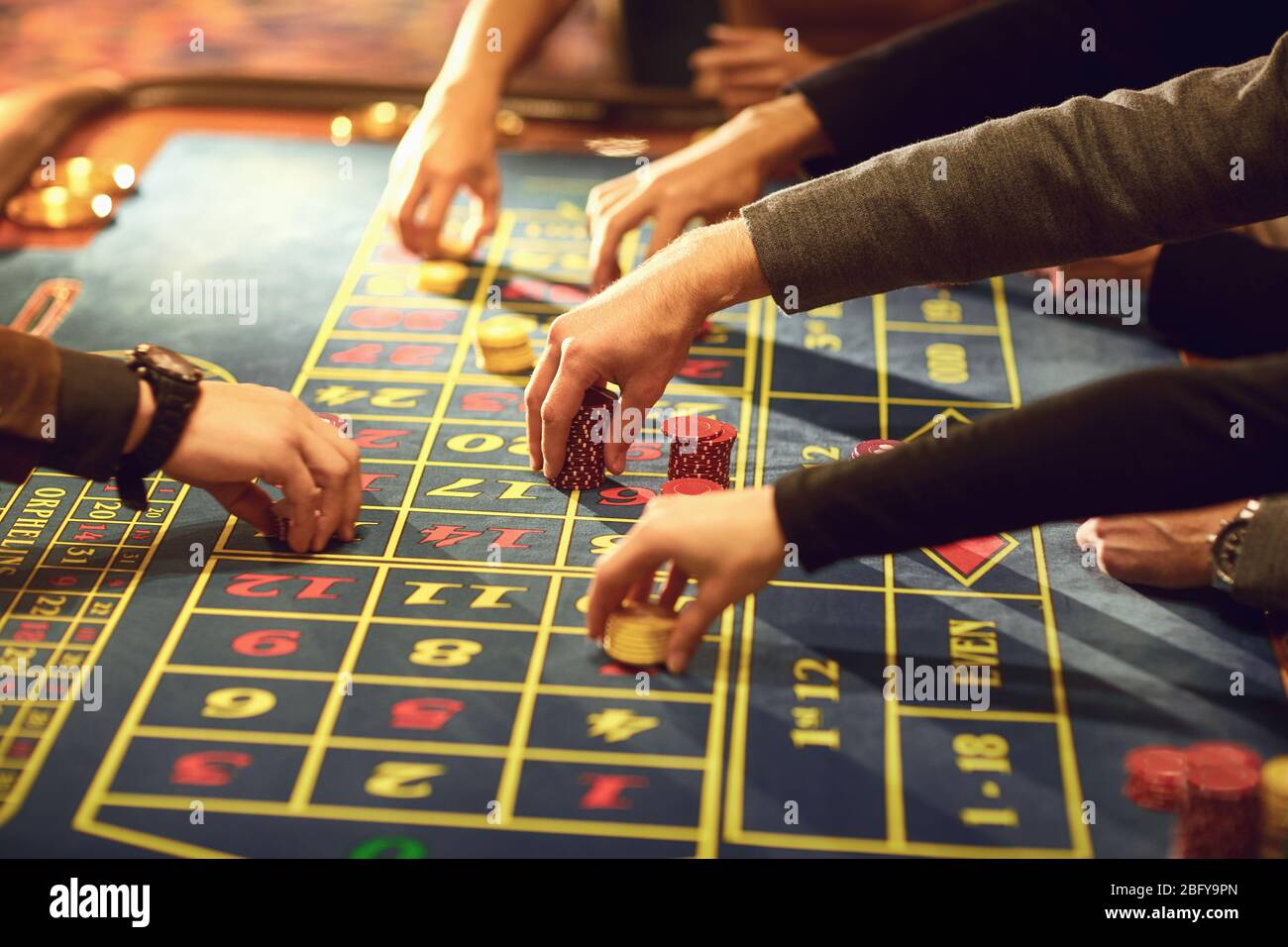 Close-up of hands with chips for gambling on a casino roulette table. Stock Photo