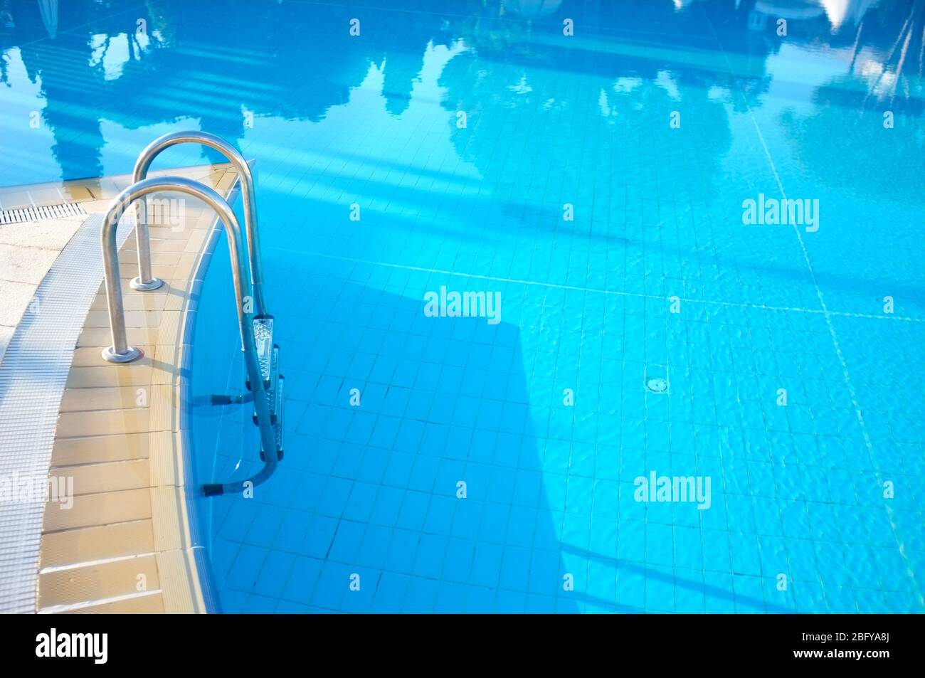 Hotel swimming pool with sunny reflections Stock Photo - Alamy
