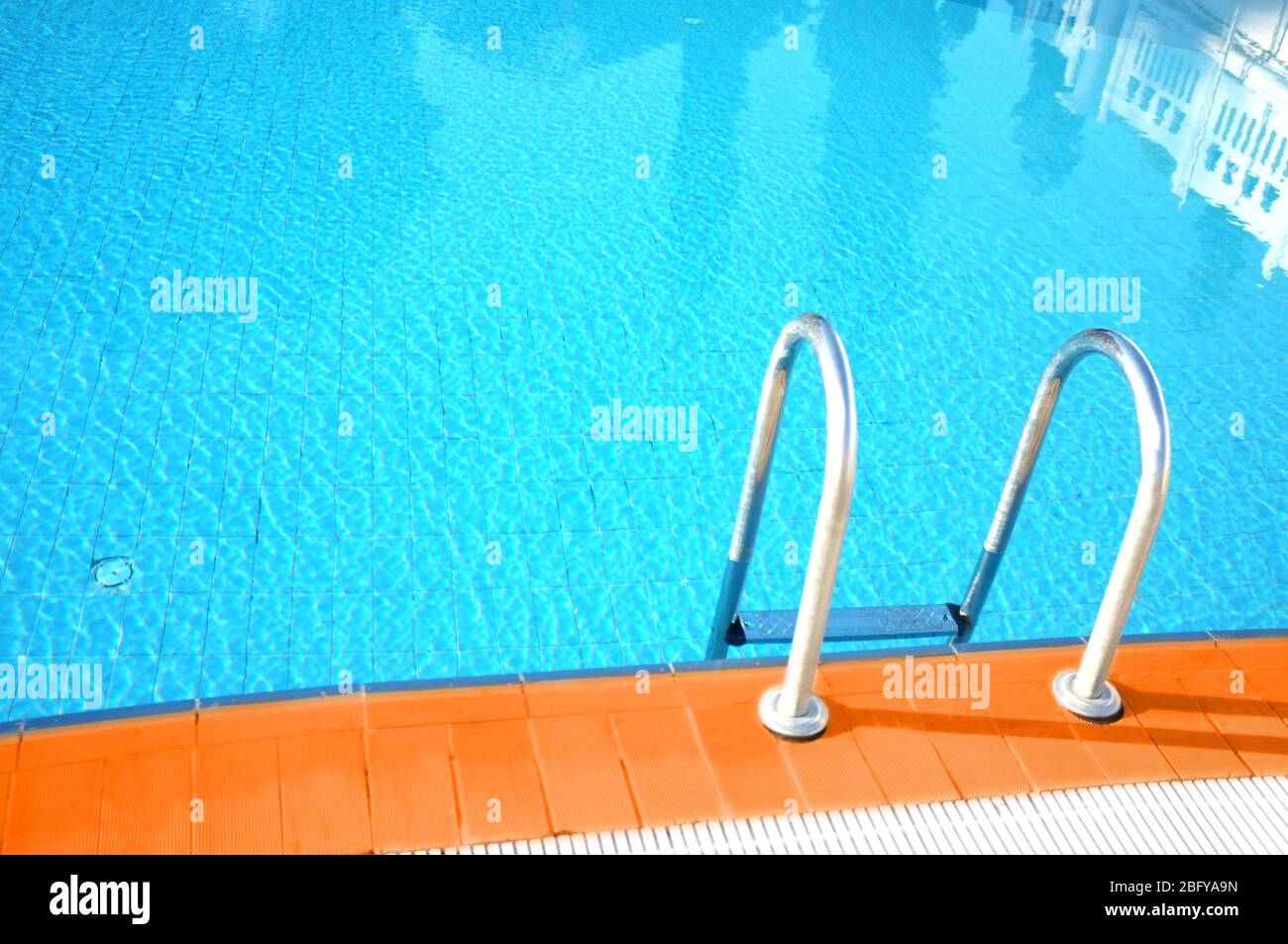Hotel swimming pool with sunny reflections Stock Photo - Alamy