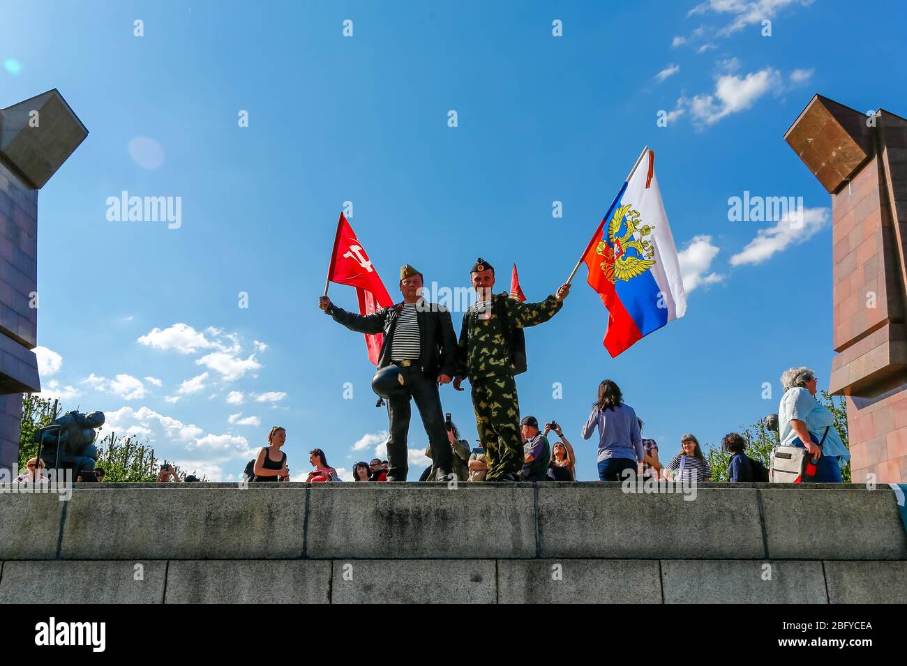 May 9, 2016, Berlin, at the Soviet War Memorial in Treptower Park (Treptower War Memorial), a memorial and at the same time a military cemetery, numerous Russians and German-Russians with many colorful flags commemorate the 71st day of victory at the end of the Second World War. The memorial was erected in Germany in 1949 on the instructions of the Soviet military administration to honor the soldiers of the Red Army who died in World War II. Over 7000 of the soldiers who died in the Schlaughs around Berlin are buried here. Men, some in uniform, pose with the Russian and Soviet national flags. Stock Photo