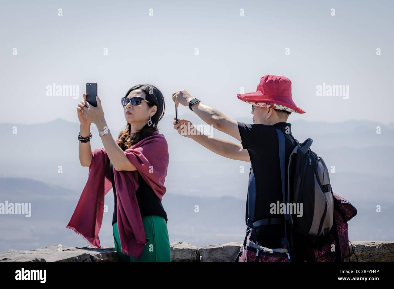 Asian tourist couple taking holiday snapshots wit phone cameras from Table Mountain Cape Town South Africa Stock Photo