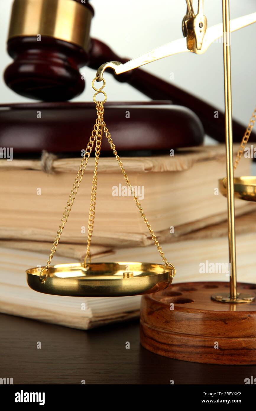 Golden scales of justice, gavel and books on grey background Stock ...